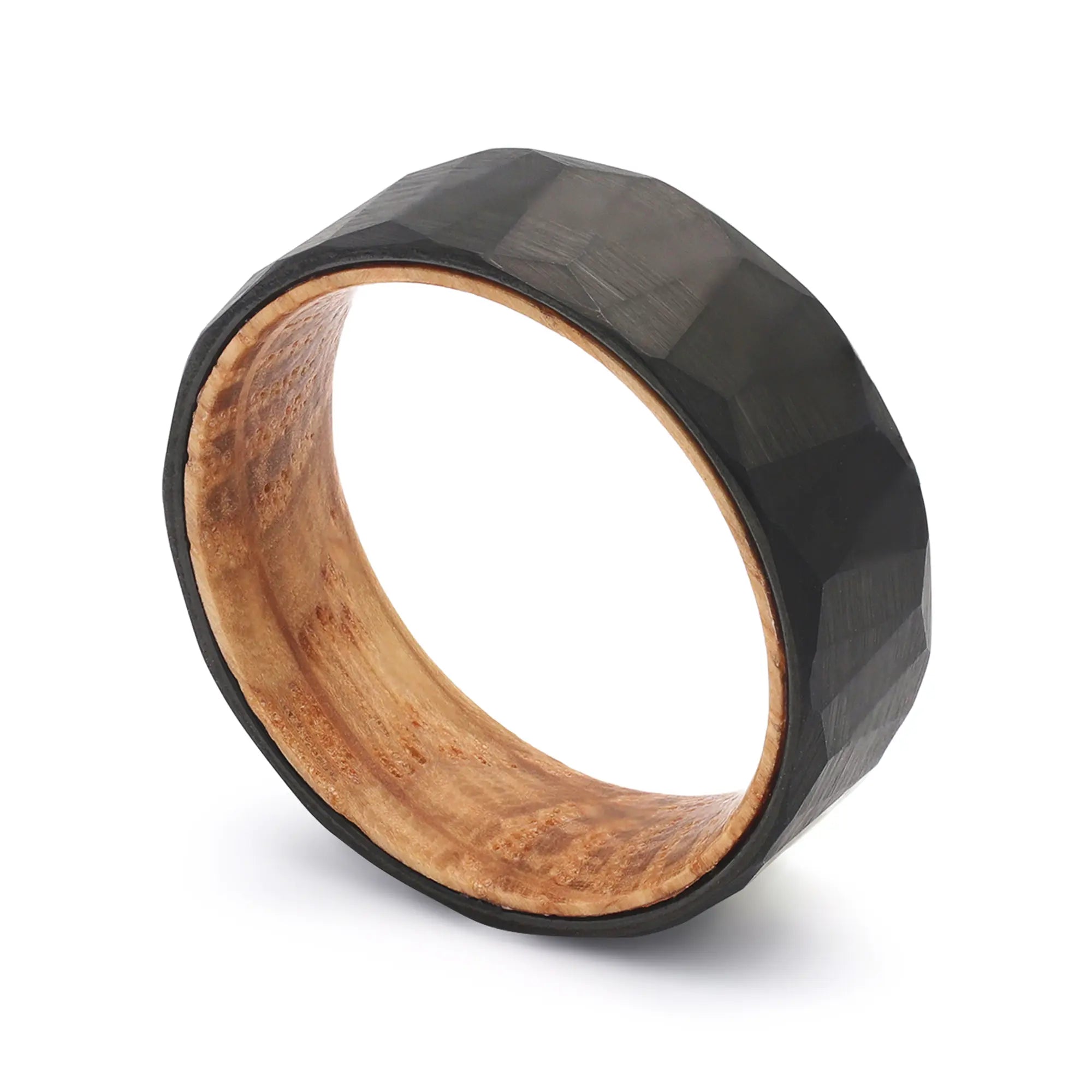 Angled close-up of a black tungsten geometric wedding ring with a real whiskey barrel oak wood sleeve.