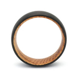Side profile of a black tungsten whiskey barrel wedding ring with a reclaimed oak wood interior.