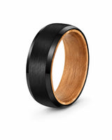 Black brushed tungsten wedding ring with polished beveled edges and a whiskey barrel wood interior at a 35 degree studio angle on a white background.