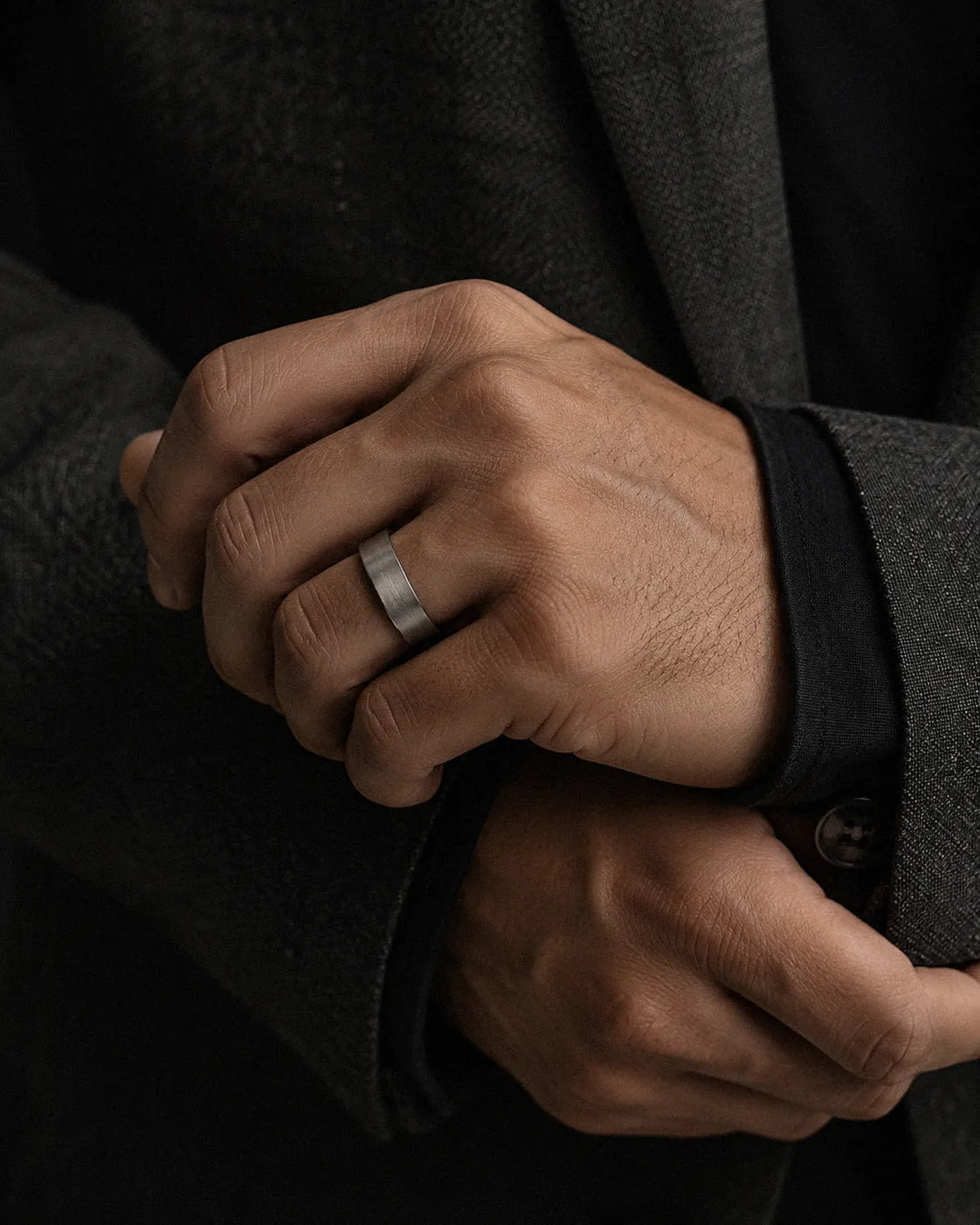 Man wearing a brushed silver and black tungsten wedding ring
