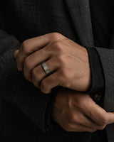 Man wearing a brushed silver and black tungsten wedding ring
