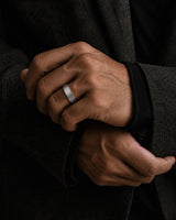 Man wearing a brushed silver and rose gold tungsten wedding ring