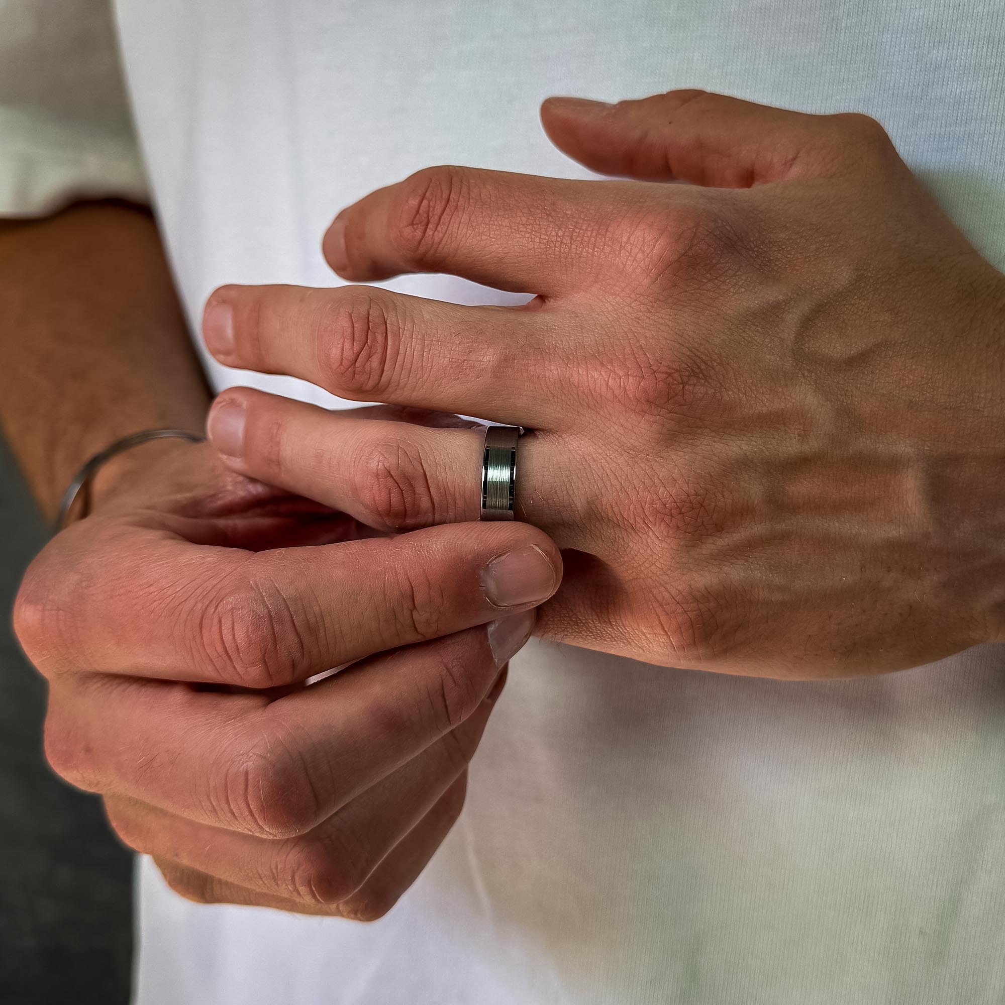 man wearing an all silver tungsten ring for men – brushed centre finish