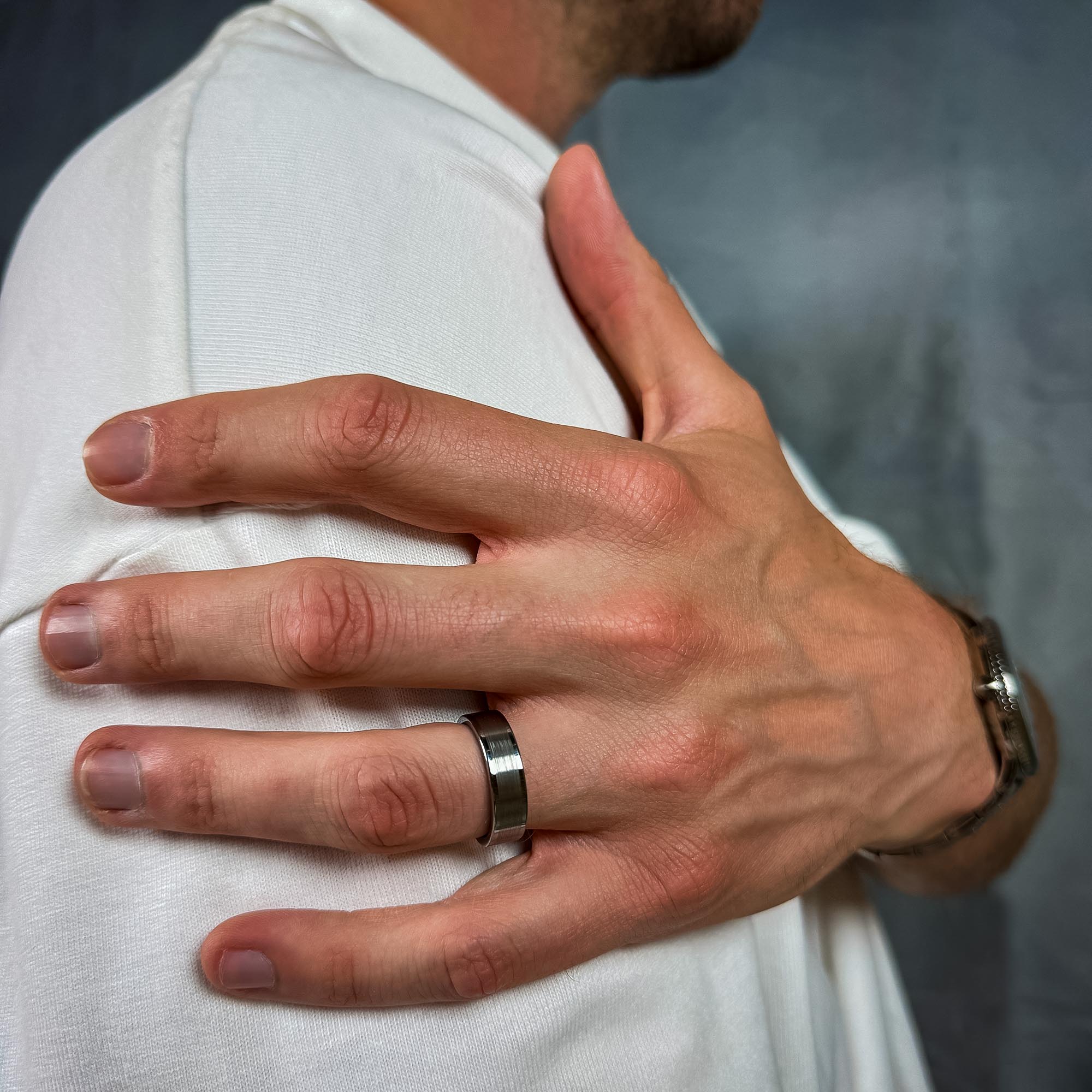 Man wearing a Brushed silver men’s wedding band with polished edges