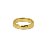 Close-up of gold faceted women’s wedding ring with comfort fit design