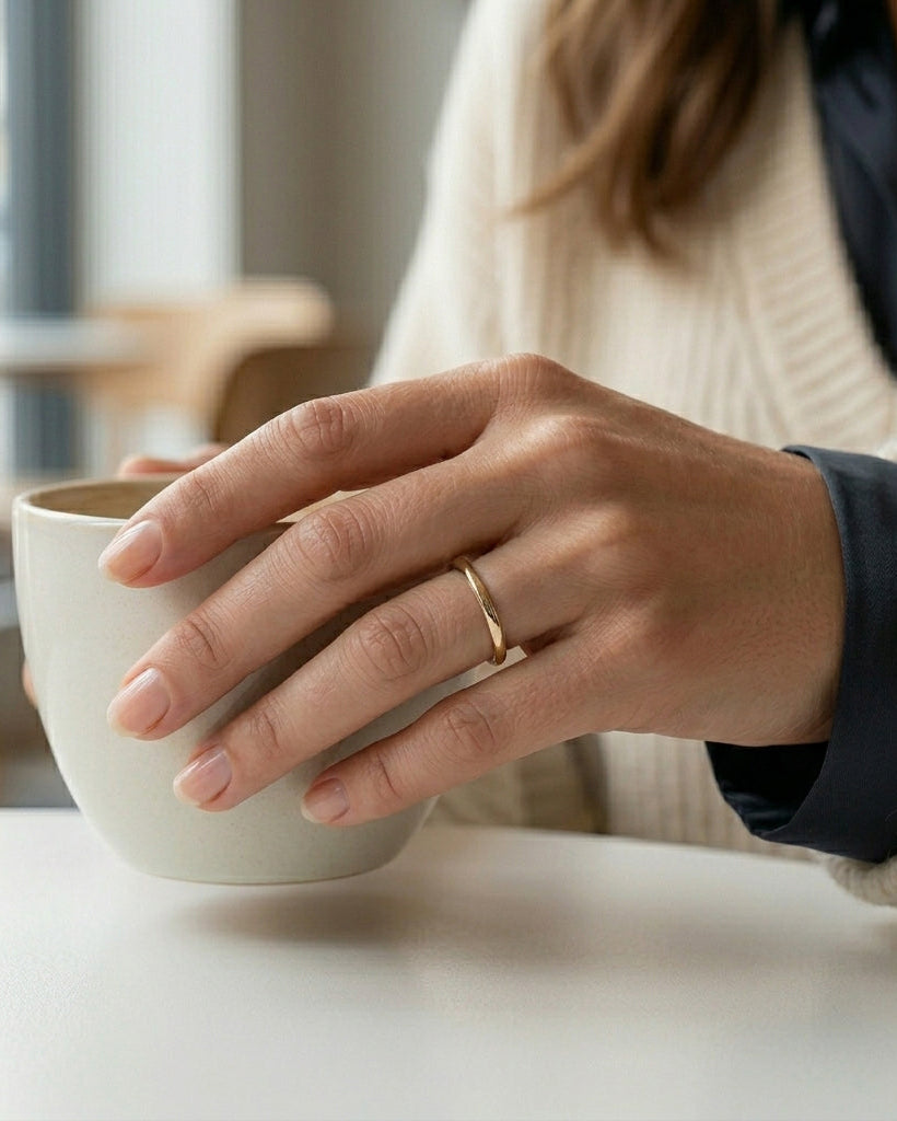 woman wearing a thin gold tungsten wedding band