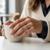 woman wearing a polished gold tungsten ring whilst holding a coffee cup