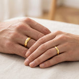 His and hers gold wedding rings set on hands