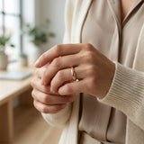 Close-up of a person wearing a ring with a blurred indoor background