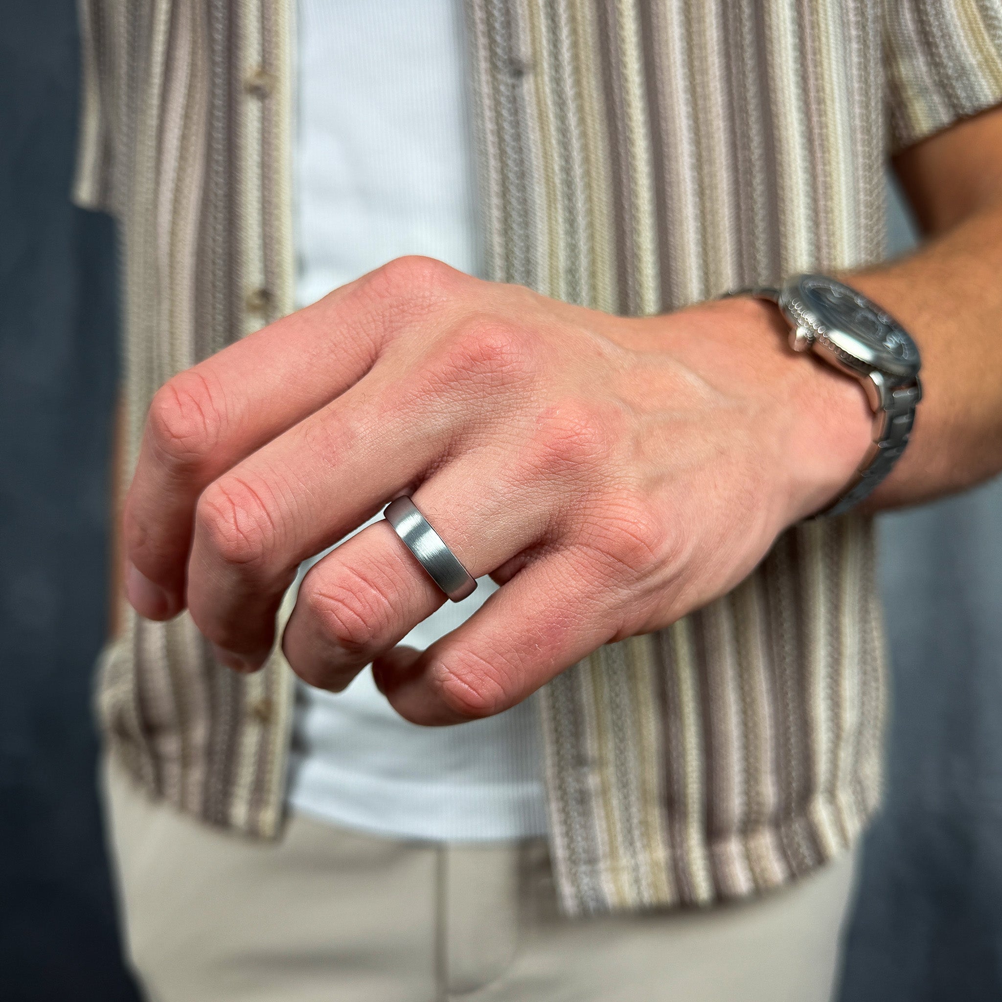 close up of a man wearing a brushed silver tungsten wedding ring