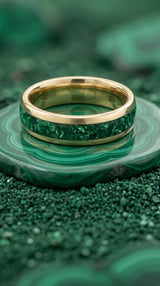 gold emerald wedding ring photographed on green background