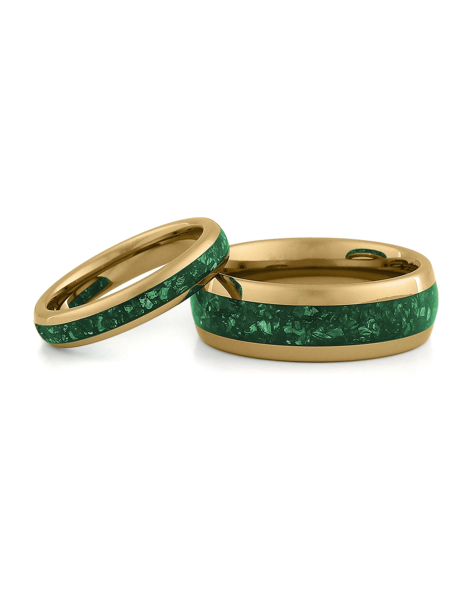 Matching gold wedding bands with green emerald stone inlays