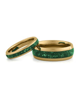 Matching gold wedding bands with green emerald stone inlays