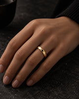 Woman wearing a gold 4mm faceted tungsten wedding ring on her ring finger