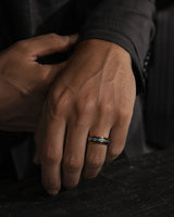 man wearing a Koa wood and abalone shell tungsten ring with polished gold finish