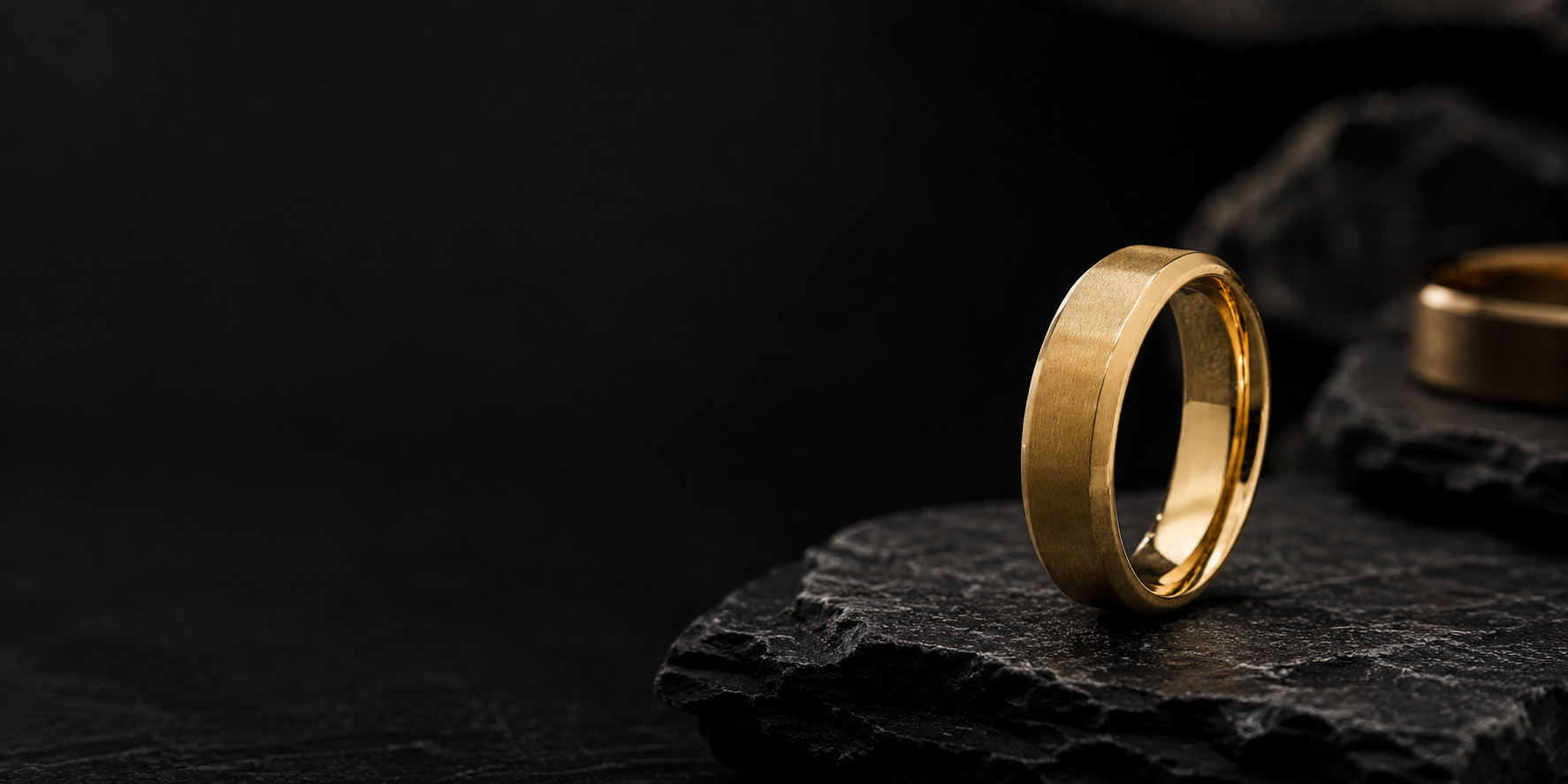 Premium cinematic product photograph of a brushed gold men’s wedding ring with dark masculine editorial styling