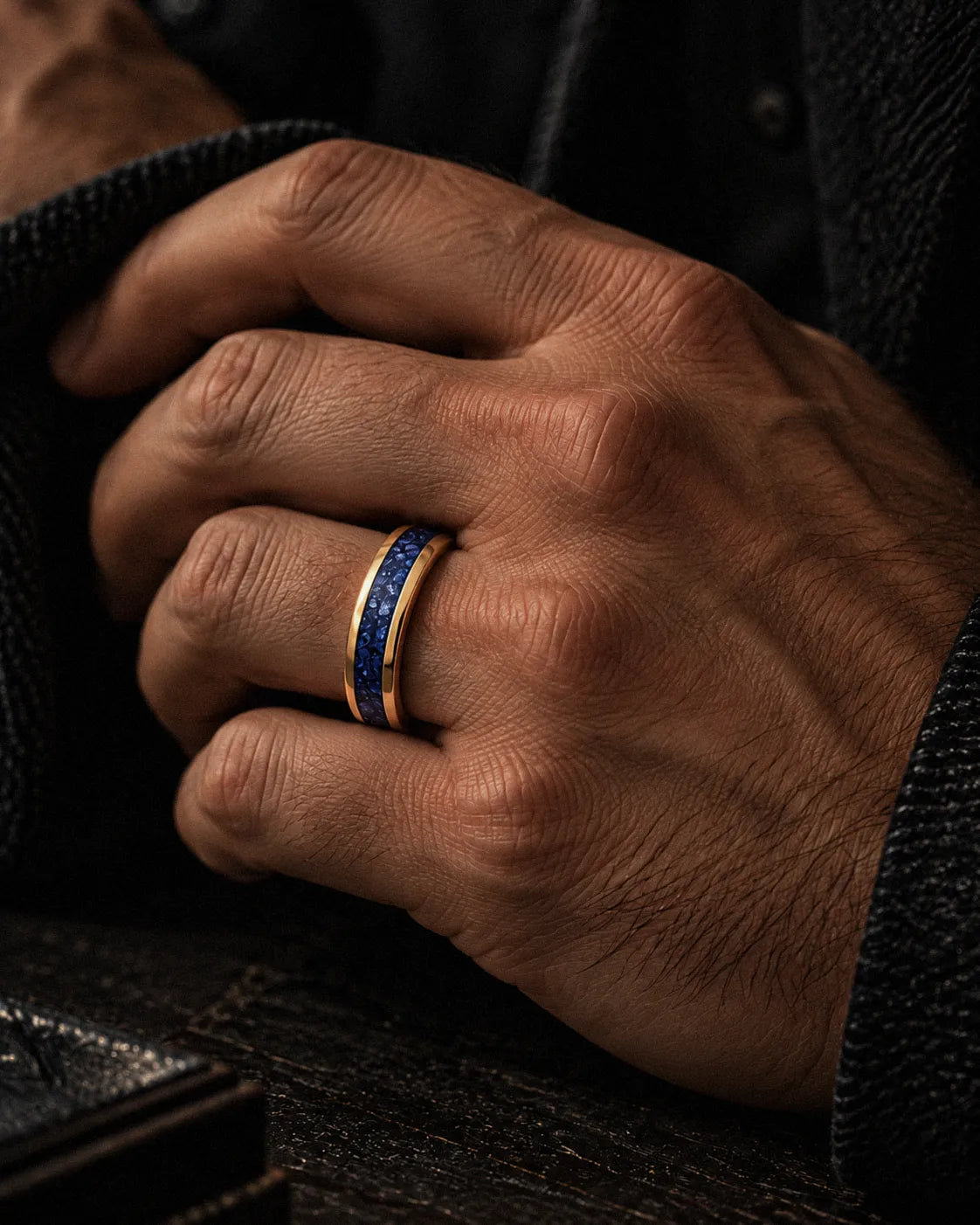 Man wearing a gold tungsten wedding ring with blue sapphire inlay