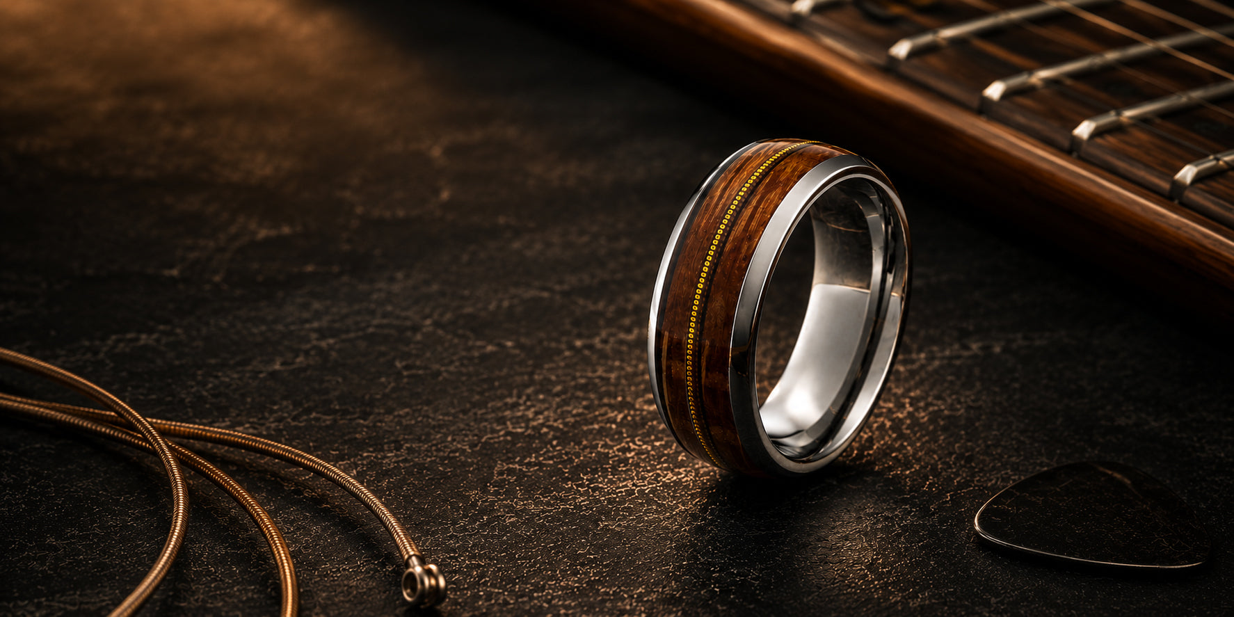 Luxury desktop hero image of silver guitar string wedding ring with reclaimed wood inlay on dark rustic wood background