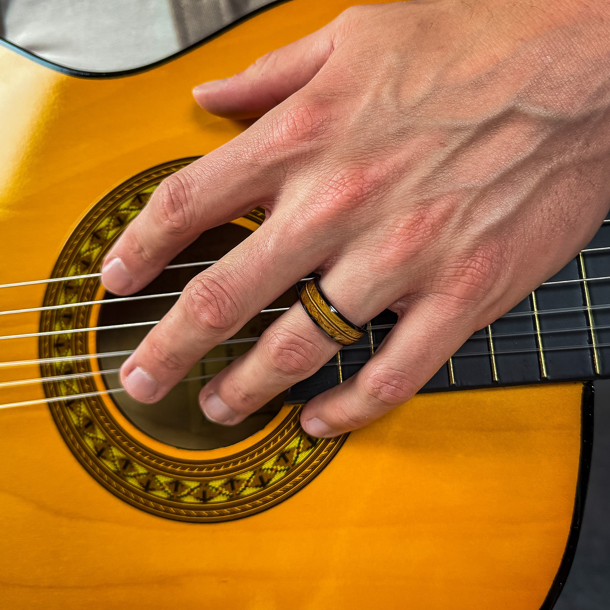 a man wearing a guitar string ring whilst playing the guitar
