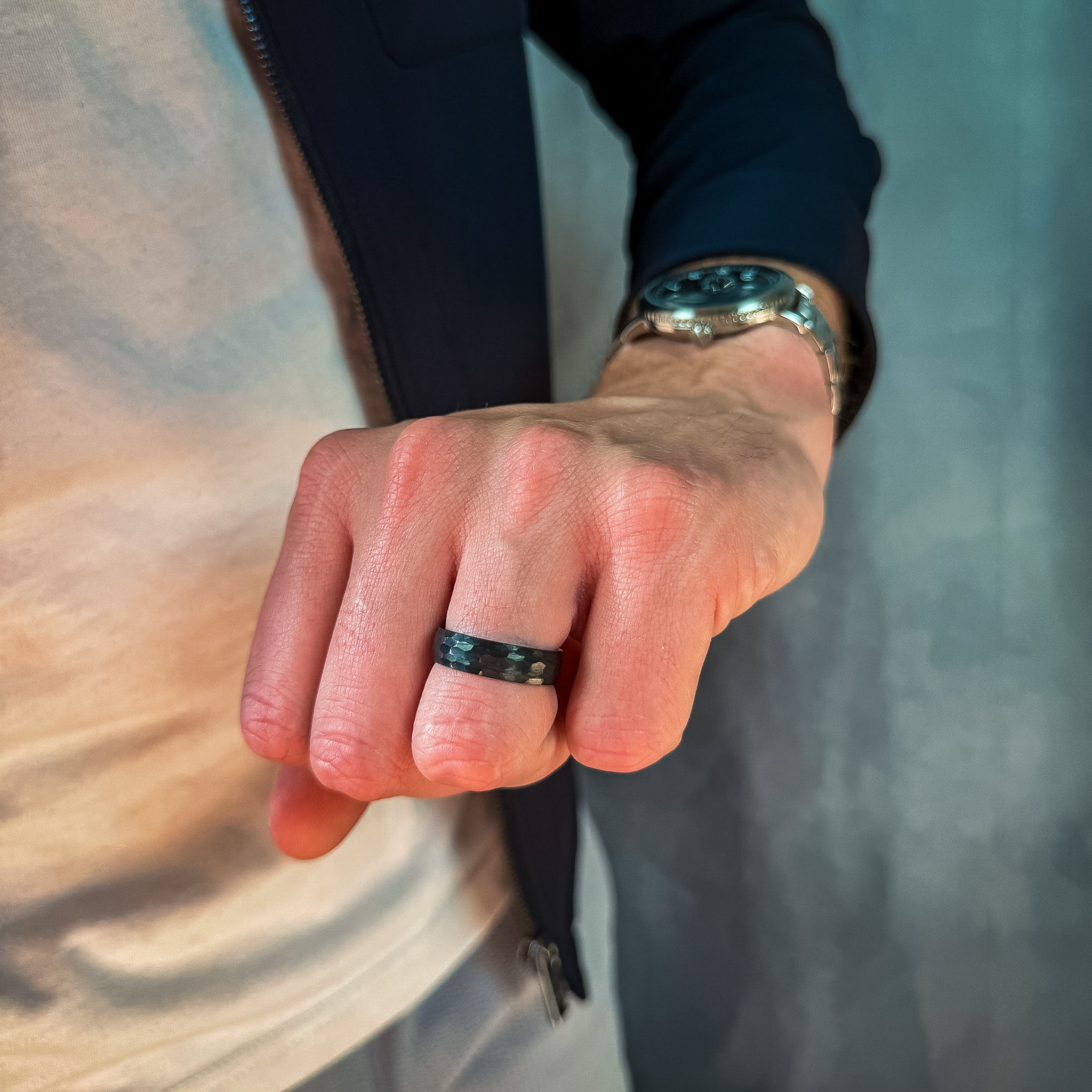 a man wearing a black hammered tungsten wedding band