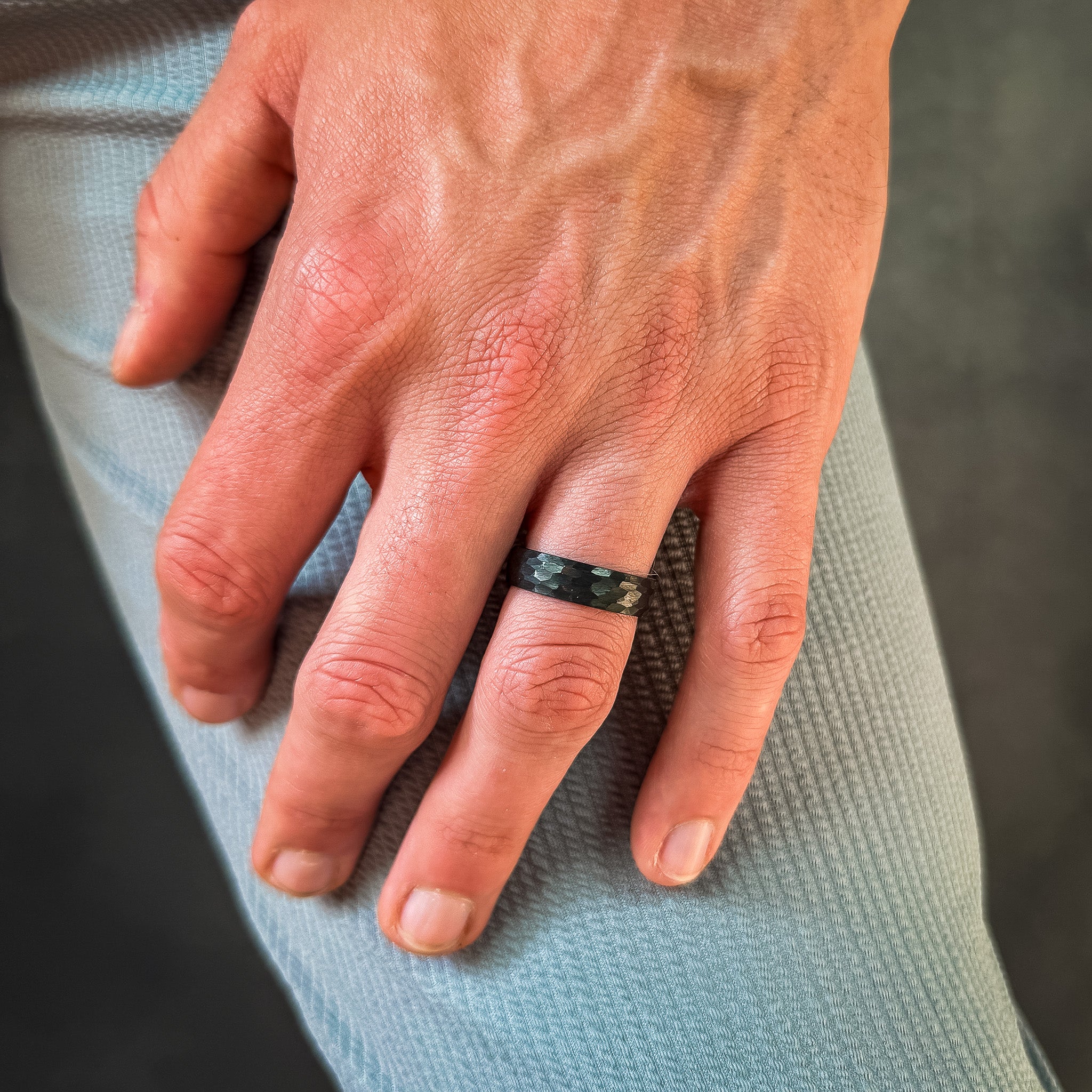 a man wearing a black hammered tungsten wedding band
