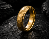 Premium editorial product photo of a hammered gold men’s wedding ring with dark moody luxury lighting