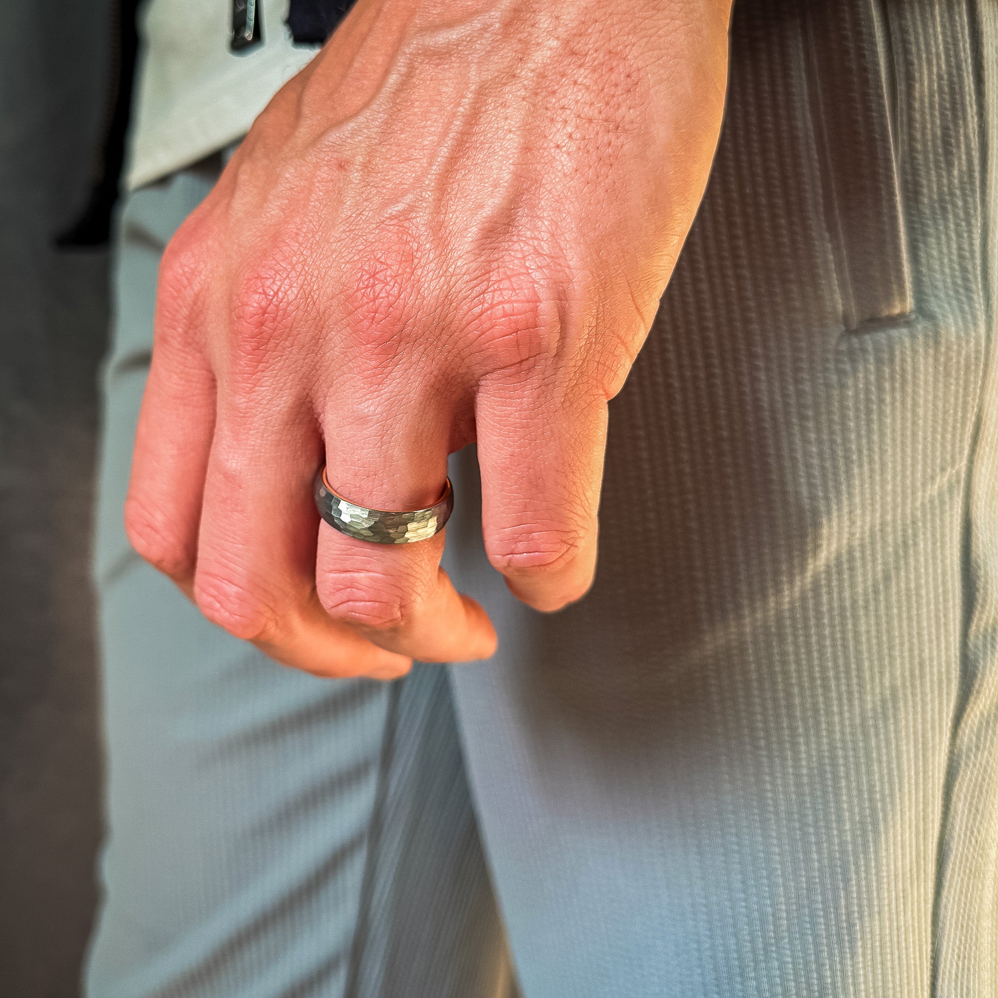 man wearing a hammered grey and rose gold tungsten wedding band