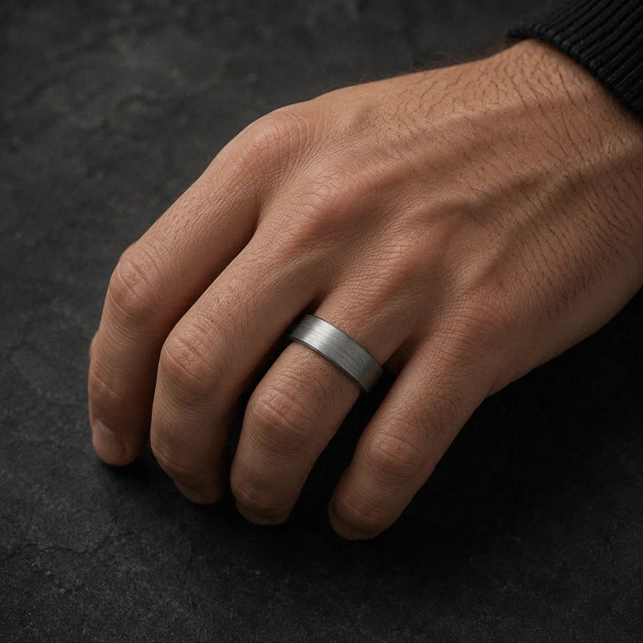 Man wearing an 8mm brushed silver tungsten wedding ring with polished black inner band