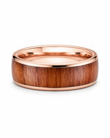 Men’s rose gold and reddish-brown wood inlay ring lying flat on a white studio background.