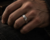 Silver tungsten antler wedding ring worn on a man’s ring finger