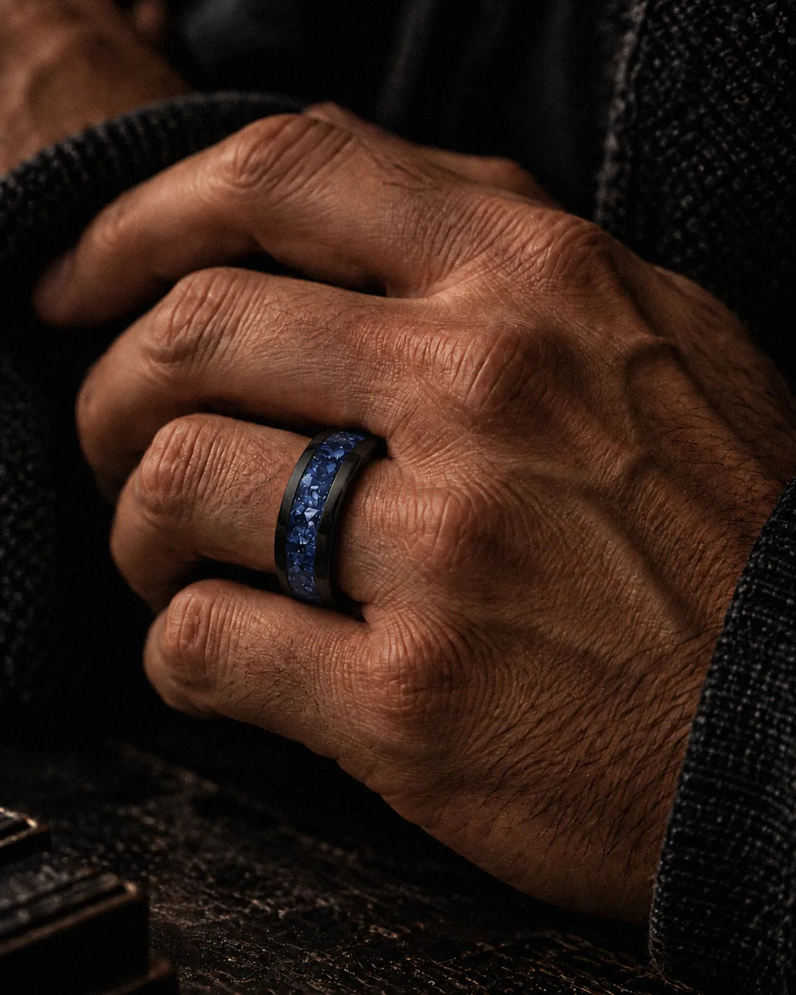 Man wearing an 8mm black tungsten wedding ring with blue sapphire inlay