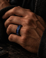 Man wearing an 8mm black tungsten wedding ring with blue sapphire inlay