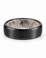 Brushed black tungsten wedding ring lying flat showing natural antler inner sleeve