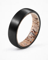 Men’s black tungsten wedding ring with brushed finish and natural antler inner sleeve