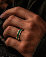 Man wearing a 6mm gold wedding ring with crushed emerald gemstone inlay