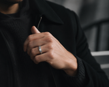 Man wearing a brushed gunmetal tungsten wedding ring with dark modern outfit and urban luxury aesthetic