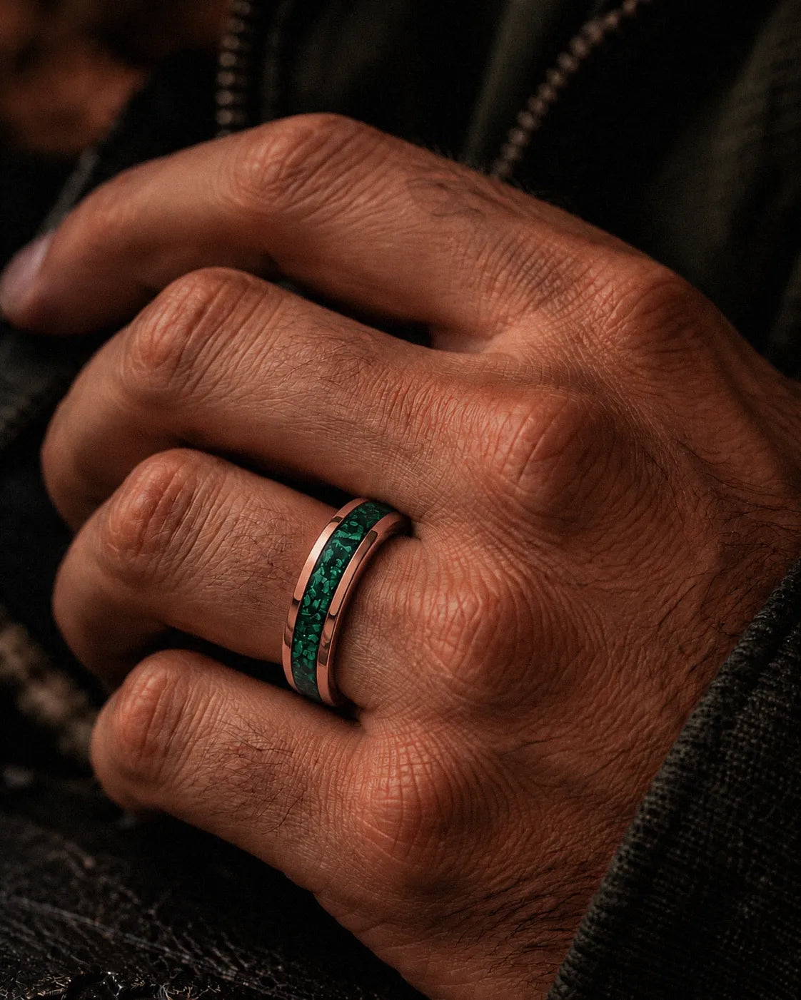 Man wearing a 6mm rose gold wedding ring with crushed emerald gemstone inlay