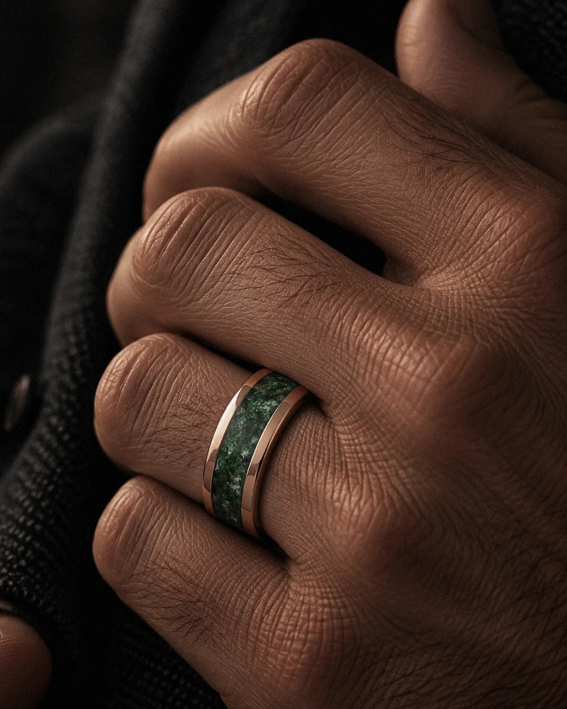 Man wearing a rose gold tungsten wedding ring with a natural green moss agate inlay.