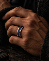 Man wearing an 8mm rose gold tungsten wedding ring with blue sapphire inlay
