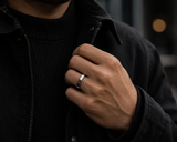 Man wearing a polished silver dome wedding ring with dark knitwear and modern urban fashion styling