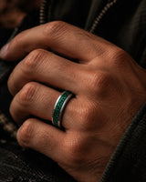 Man wearing a 6mm silver wedding ring with crushed emerald gemstone inlay