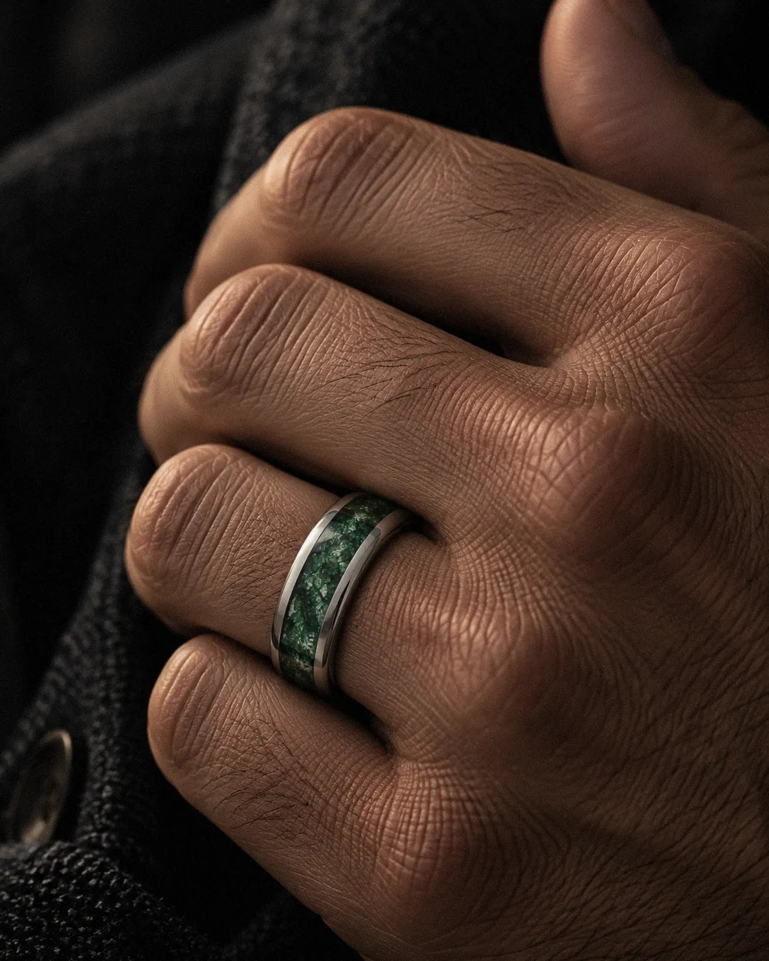 Man wearing a silver tungsten wedding ring with natural green moss agate inlay