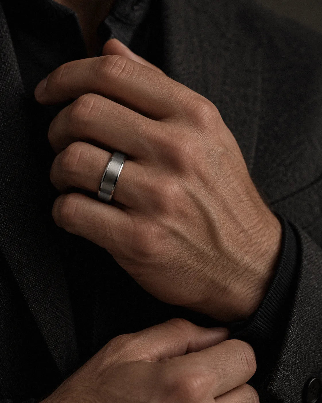 Man wearing a brushed silver tungsten wedding ring with natural antler inner sleeve