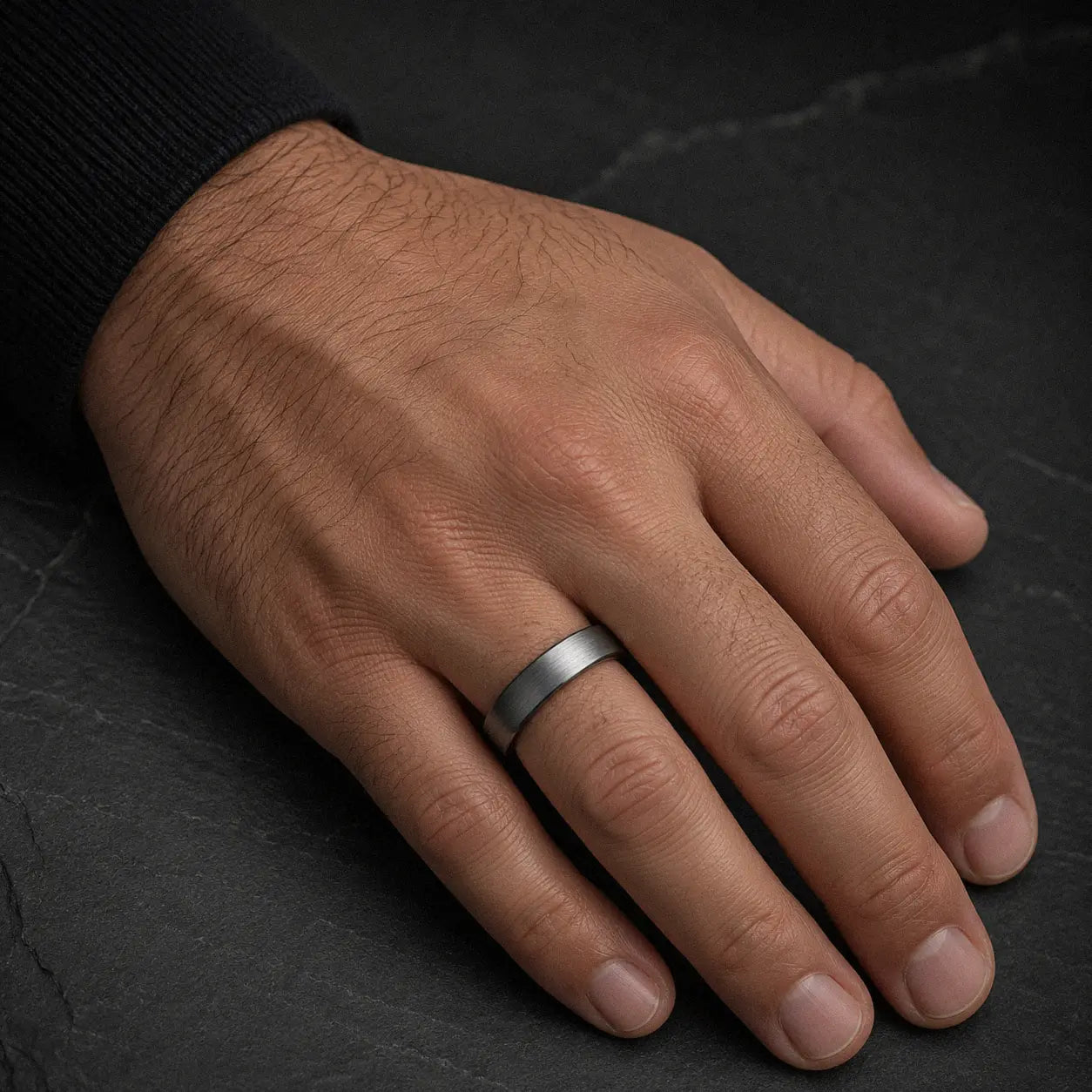 Man wearing a 4mm brushed silver tungsten wedding ring with polished black inner band