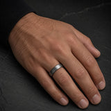Man wearing a 4mm brushed silver tungsten wedding ring with polished black inner band