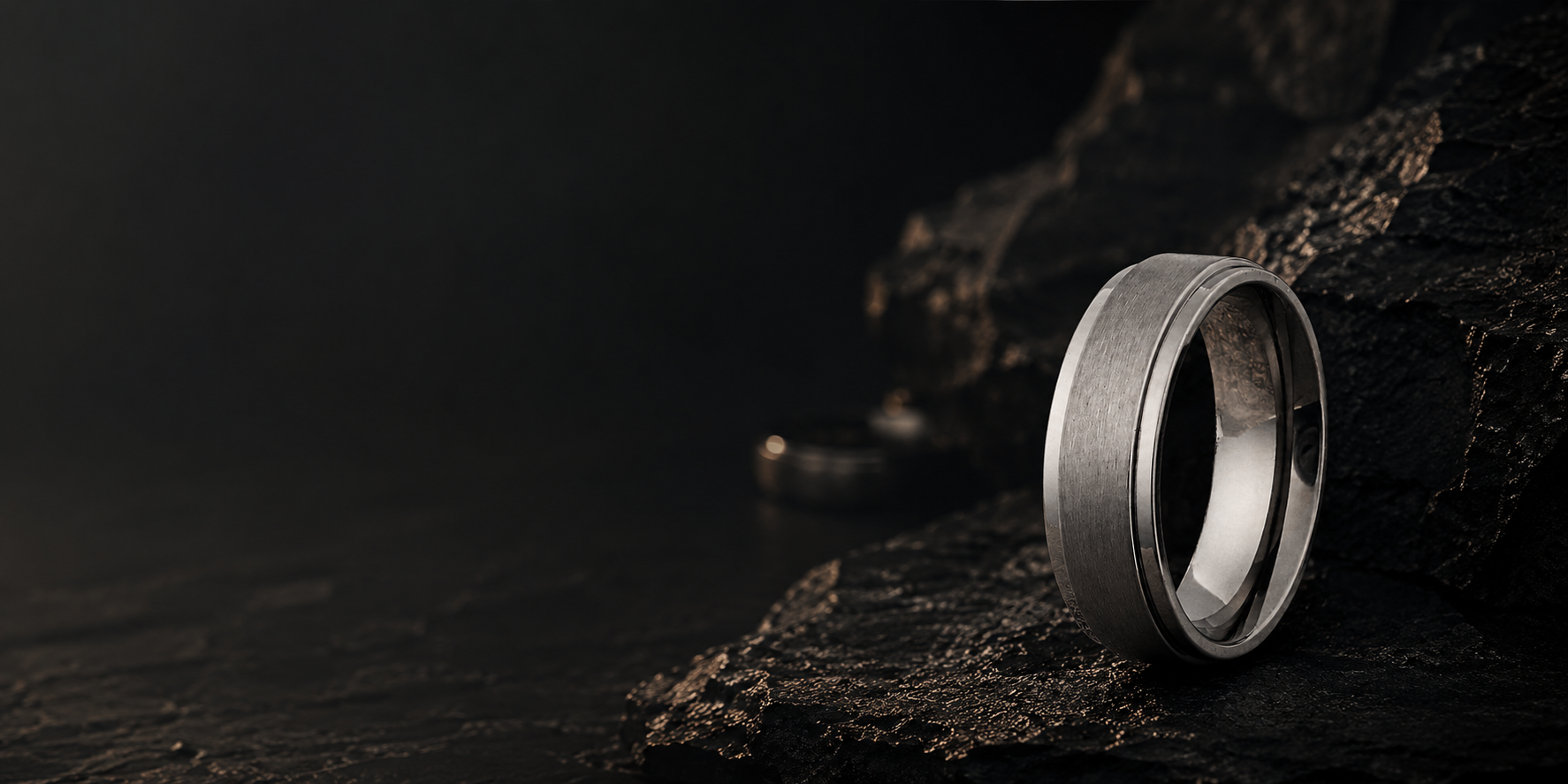 Premium brushed silver mens wedding ring on dark textured slate with moody cinematic lighting and luxury masculine styling