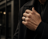 Man wearing a brushed silver tungsten wedding ring with a modern dark outfit in an urban editorial lifestyle setting