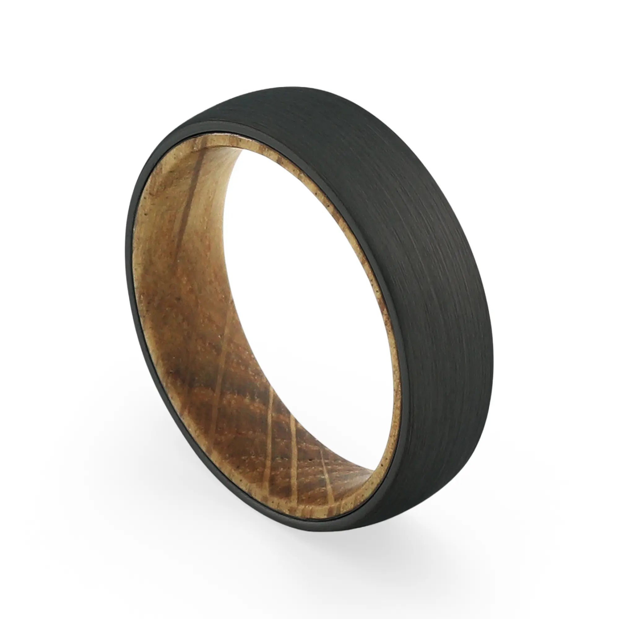 Angled view of a men's black tungsten wedding band with a real whiskey barrel wood inlay.