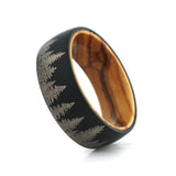 Angled view of an 8mm men's black tungsten wedding band with a forest engraving and real wood inlay.
