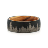 Top view of an 8mm men's black tungsten wedding band with a forest engraving and real wood inlay.